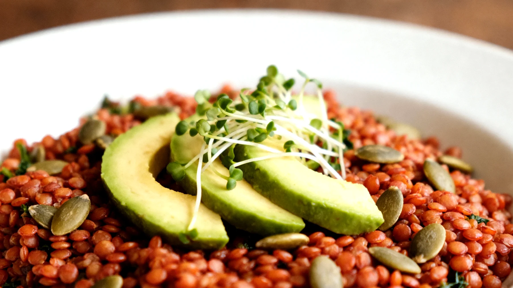Insalata di lenticchie rosse con avocado, semi di zucca e germogli di broccoli"