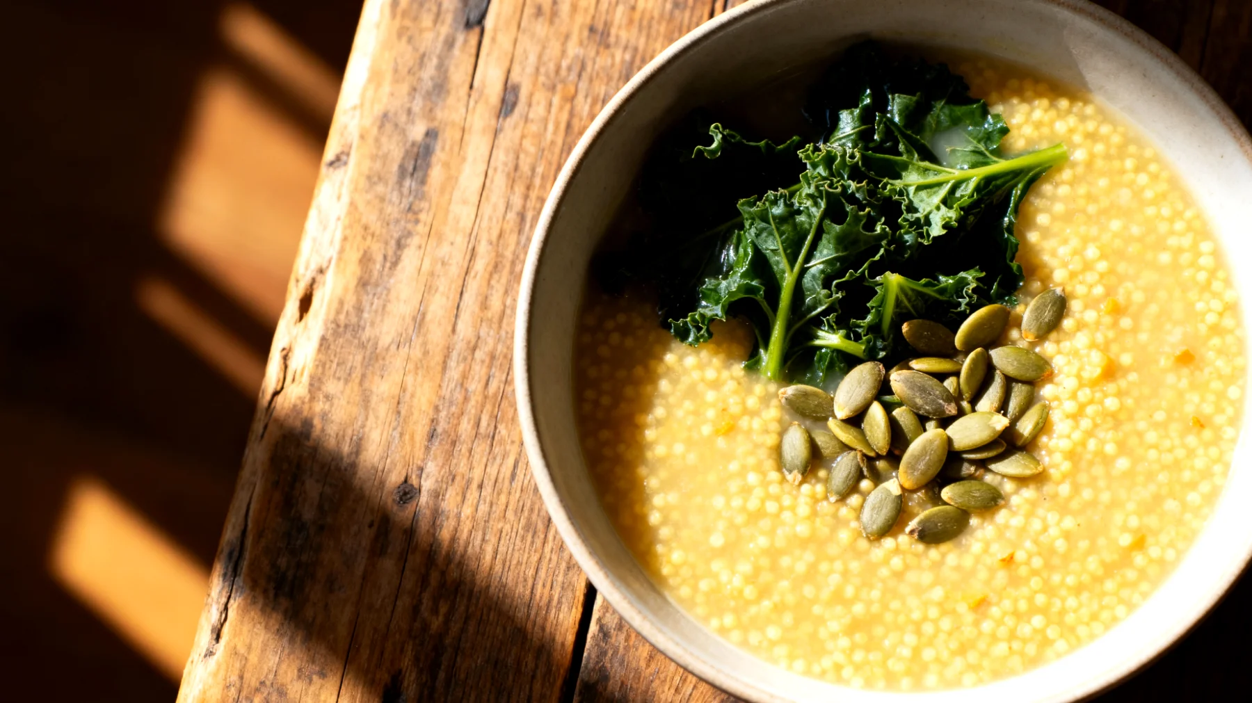 Zuppa di miglio con verdure amare e semi di zucca"